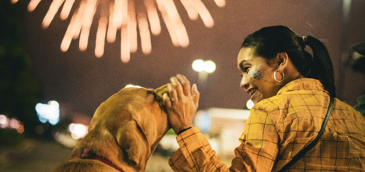 woman petting dog afraid of fireworks